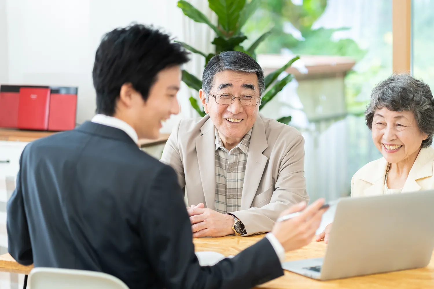 老夫婦の相談業務をするファイナンシャルプランナーの男性